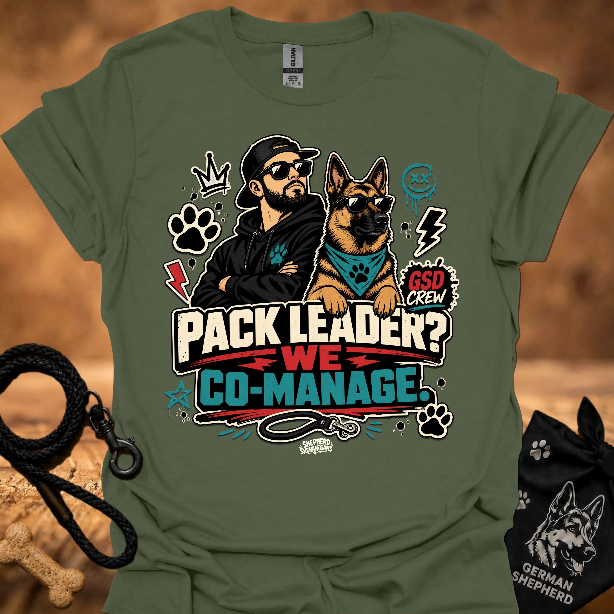Military green crew-neck short-sleeve T-shirt with illustrated dog-and-man graphic and “Co-Manage” text