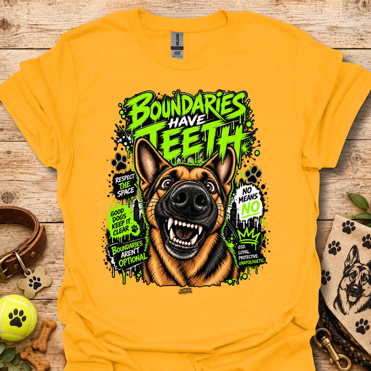 Gold T-shirt with colorful dog head graphic and 'Boundaries Have Teeth' text