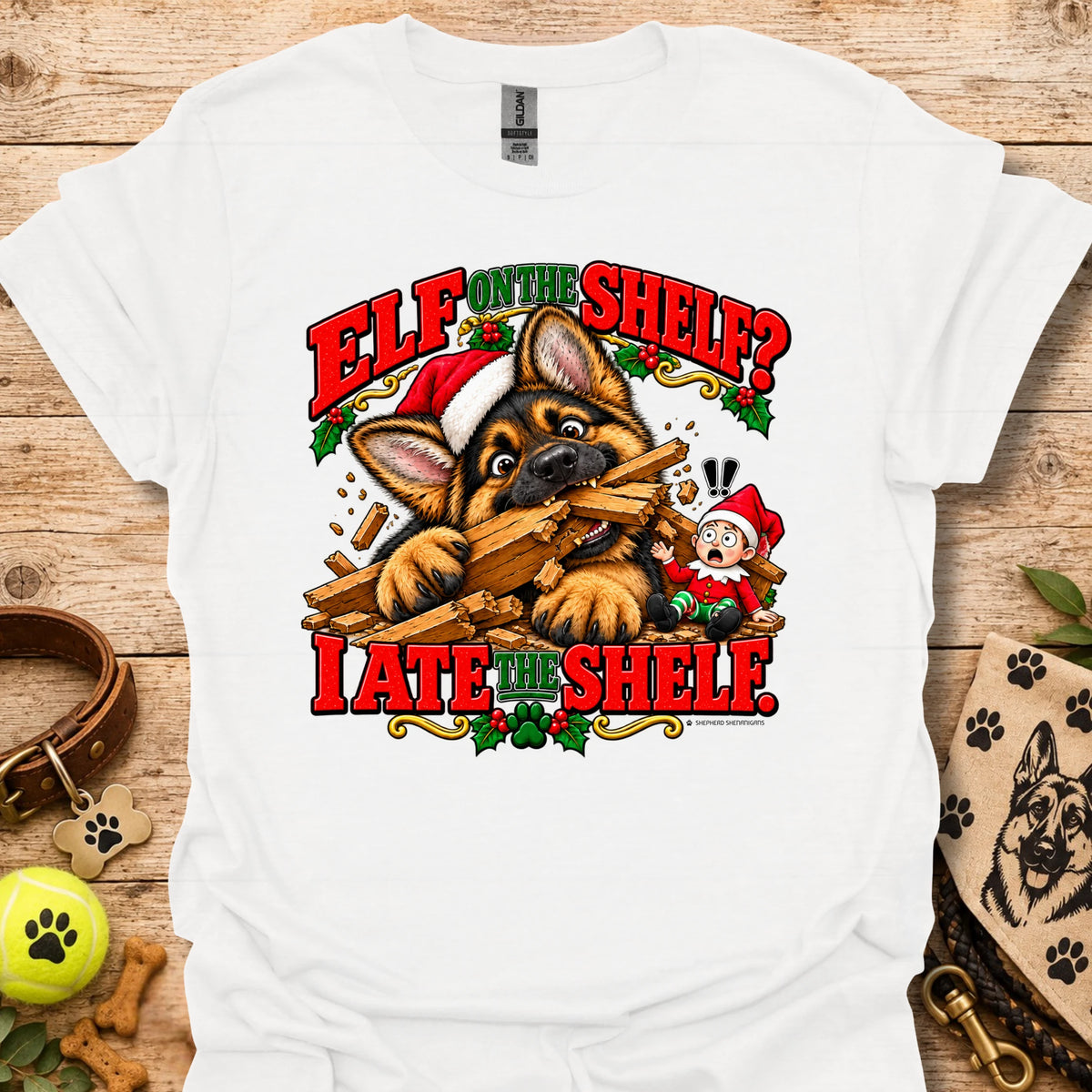 White graphic t-shirt with cat-and-wood “Elf on the Shelf?” and “I ate the shelf” print