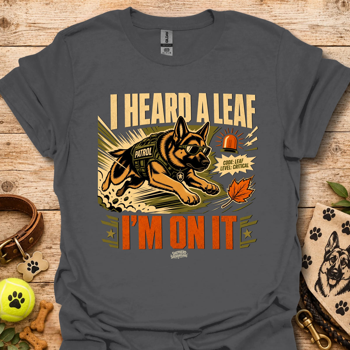 Dark gray t-shirt with dog leaf graphic and bold 'I HEARD A LEAF'/'I'M ON IT' text.
