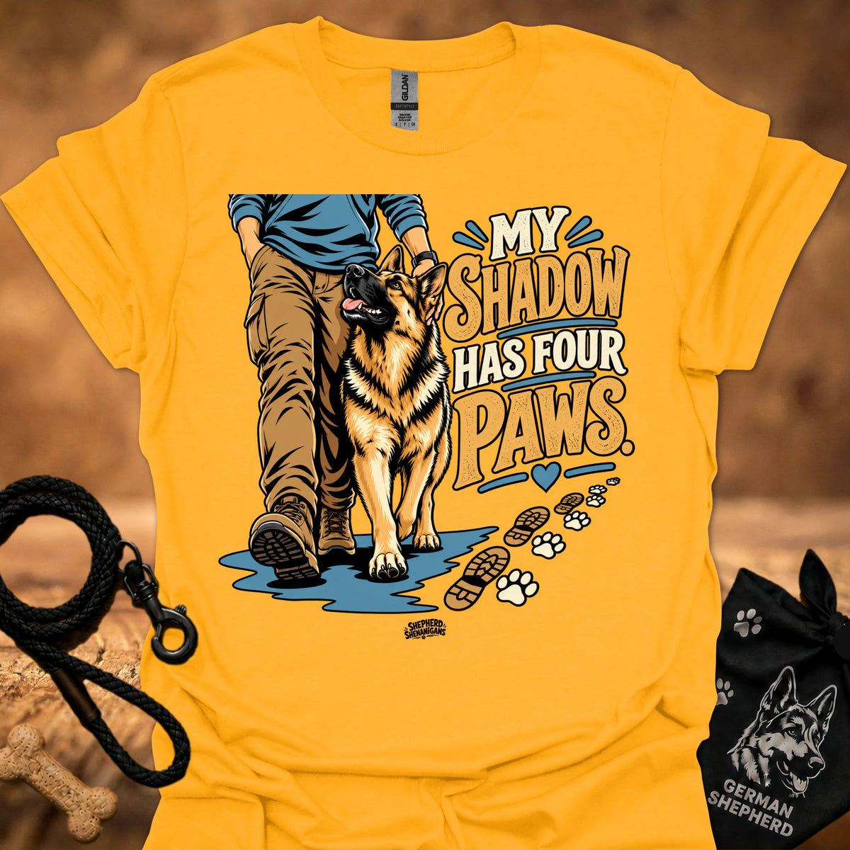 Gold T-shirt with dog graphic and “My Shadow Has Four Paws” text