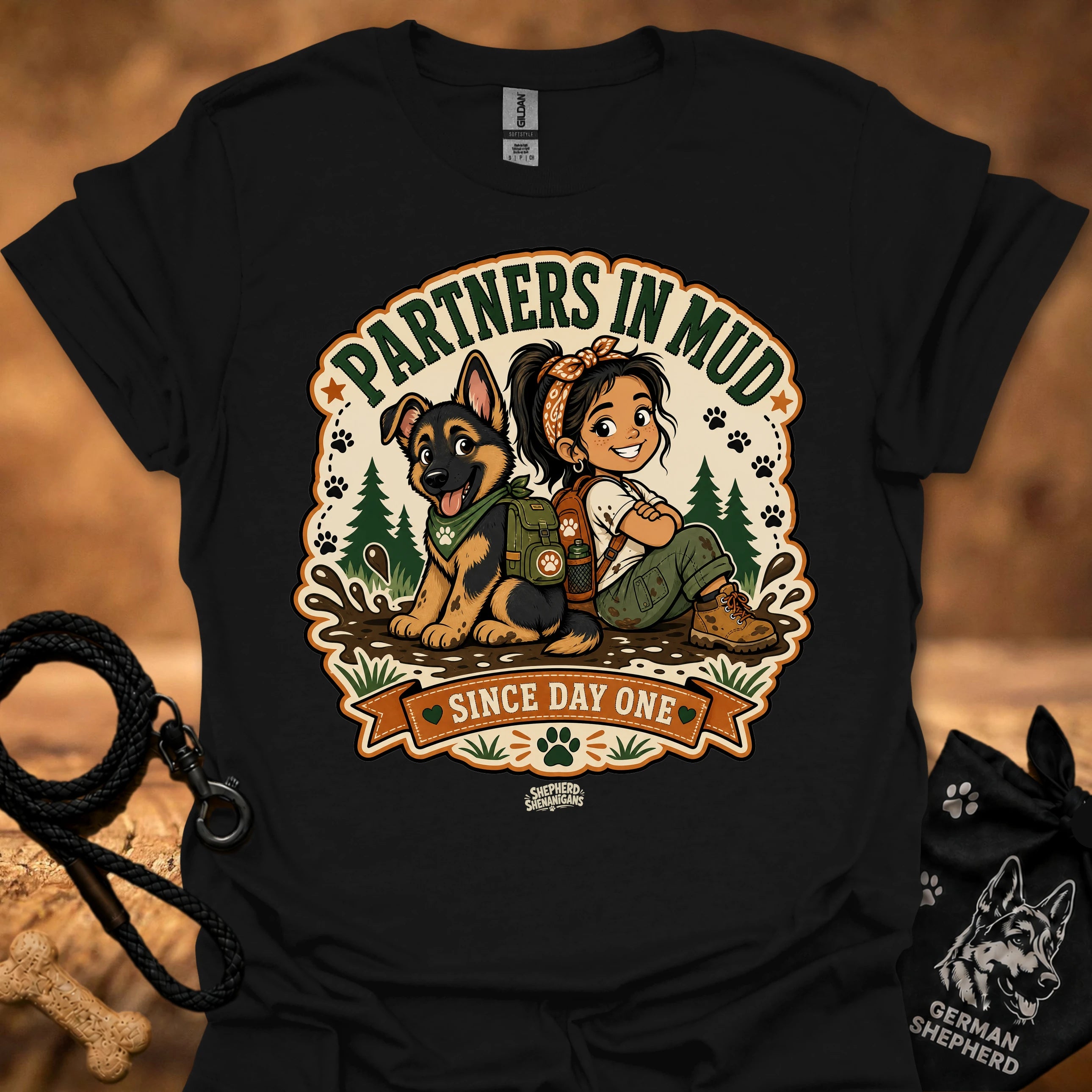 Black women’s t-shirt with “Partners in Mud” dog and girl graphic in badge
