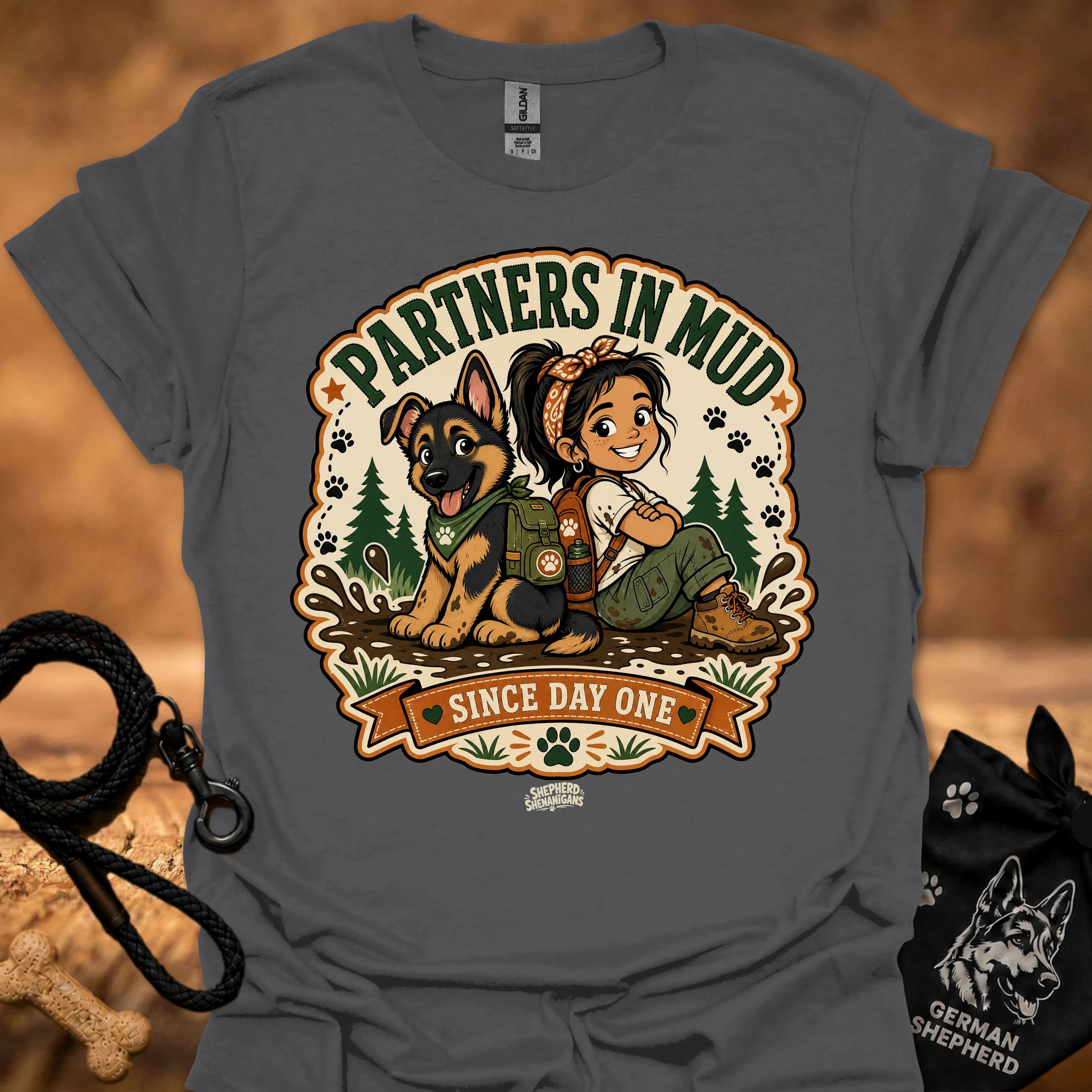 Charcoal gray women’s t-shirt with “Partners in Mud” dog and girl graphic