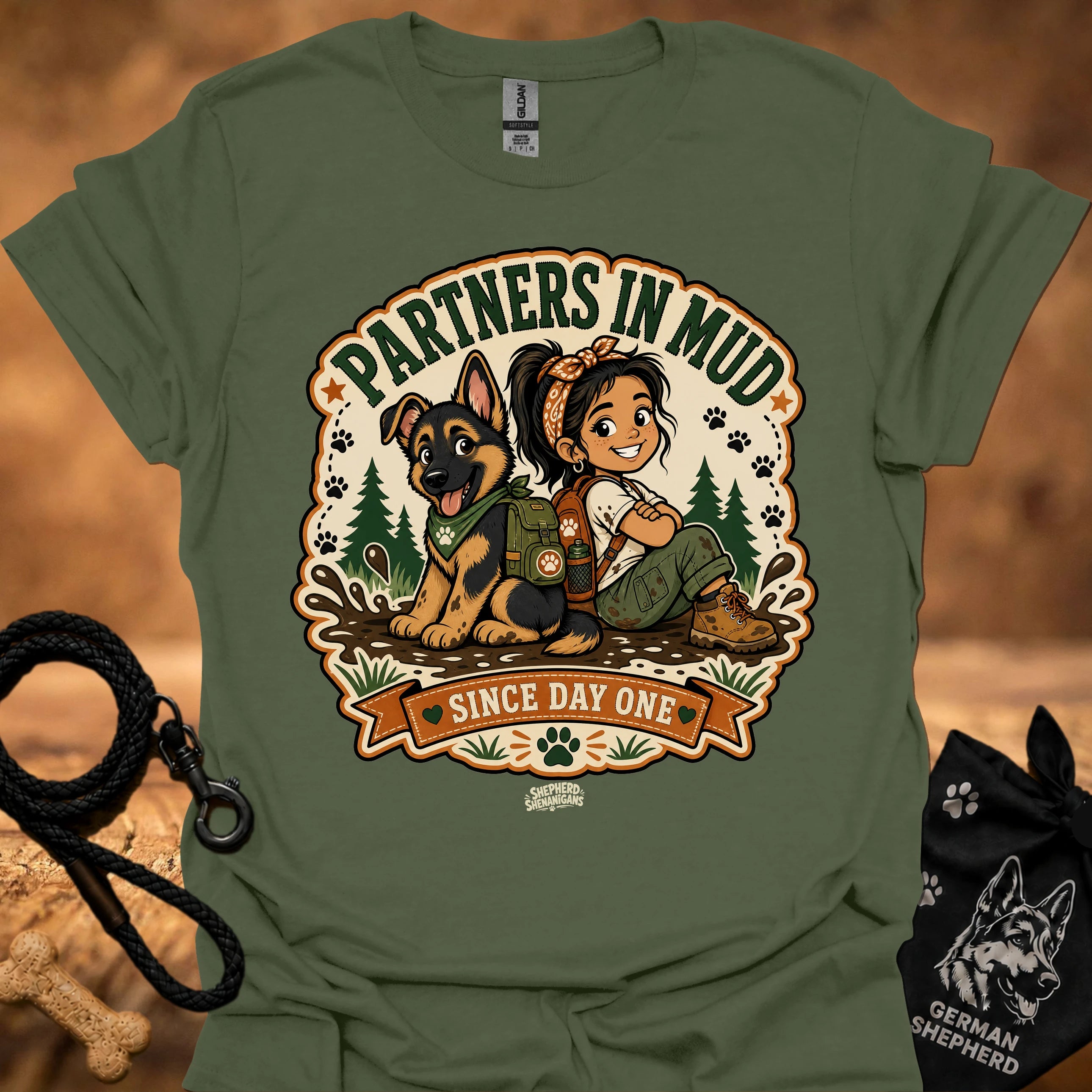 Military green women’s t-shirt with “Partners in Mud” dog and girl graphic badge