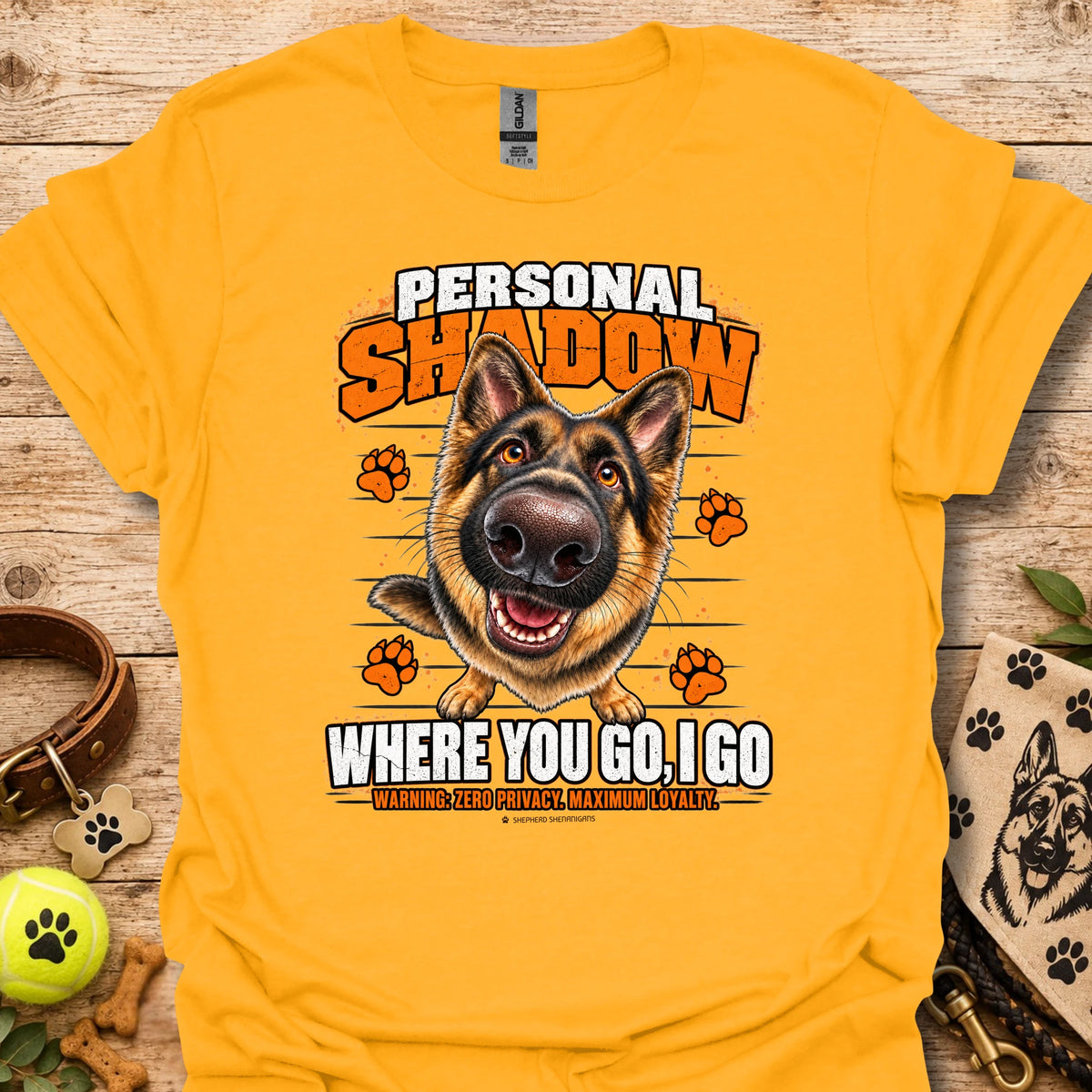 Gold T-shirt with a German shepherd graphic, orange paw prints and bold slogan