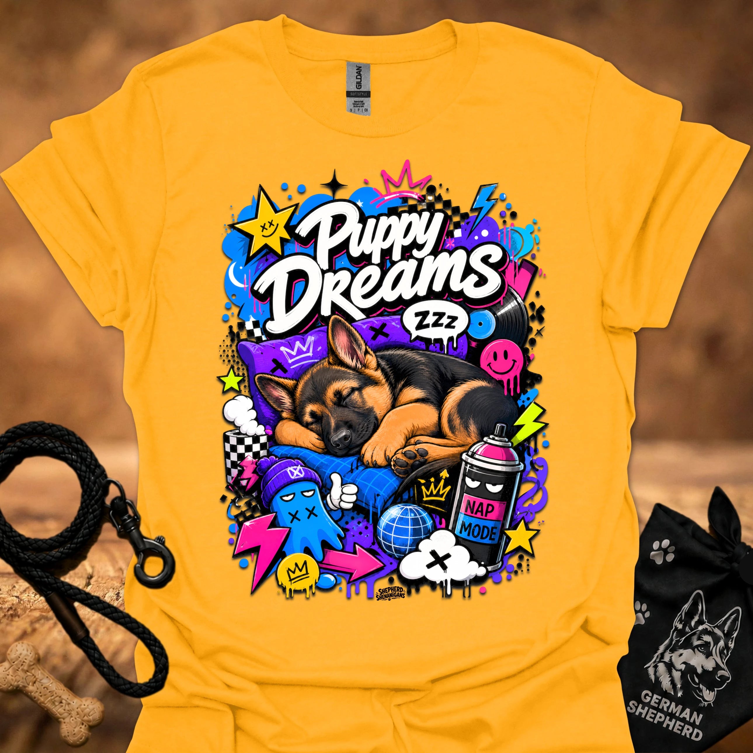 Gold T-shirt with colorful Puppy Dreams graphic of a sleeping puppy and colorful icons.