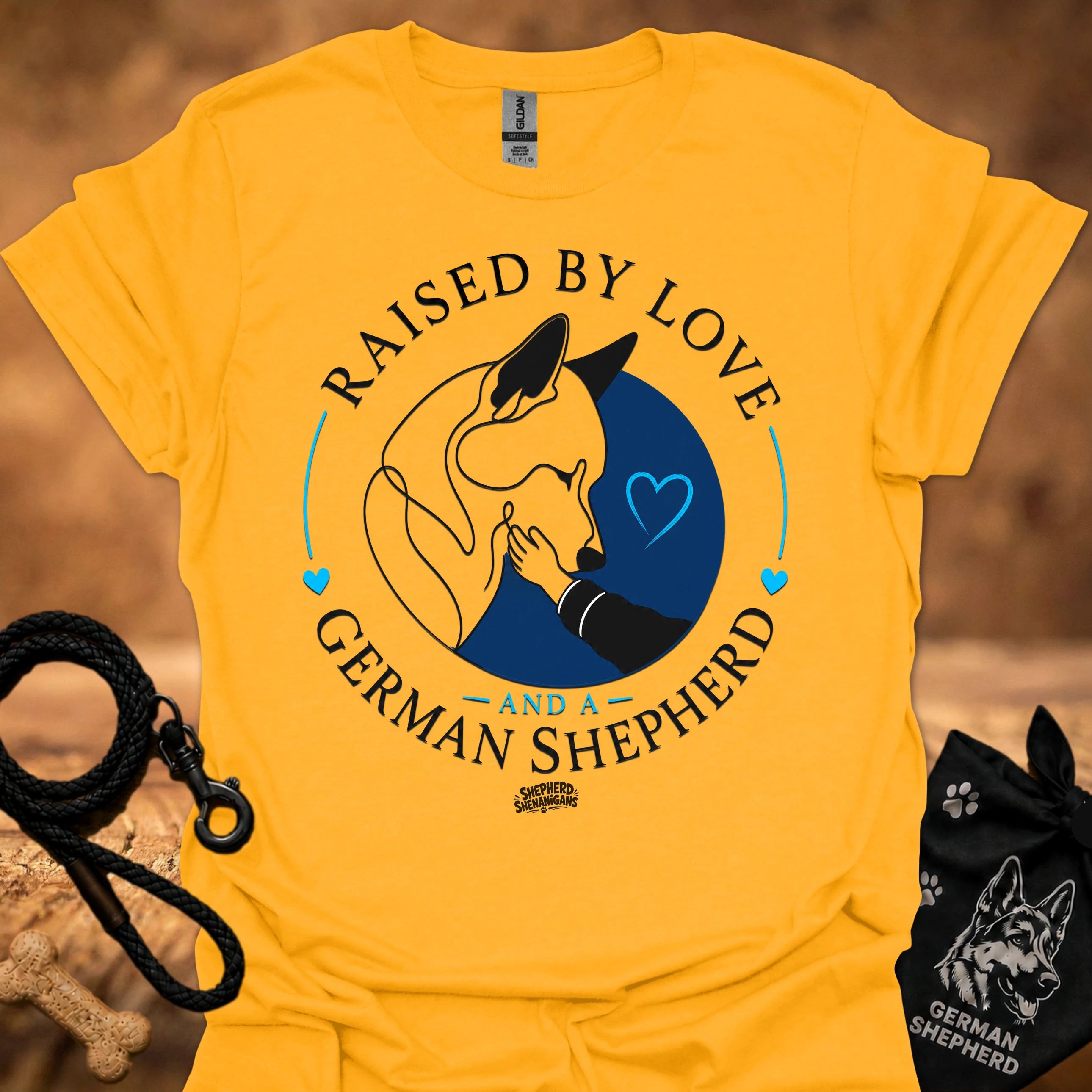 Gold T-shirt with Raised By Love German Shepherd graphic and blue heart circle