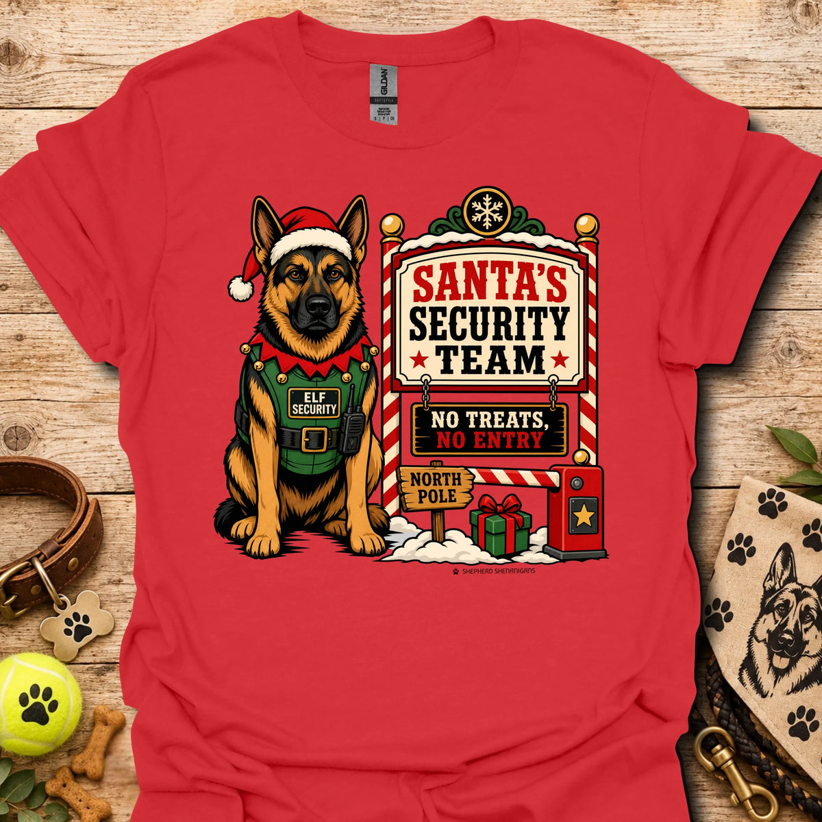 Red T-shirt with elf-dog character beside Santa's Security Team sign and icons