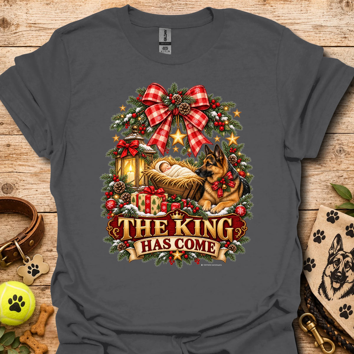 Charcoal holiday graphic T-shirt with wreath, dog, and “THE KING HAS COME” print