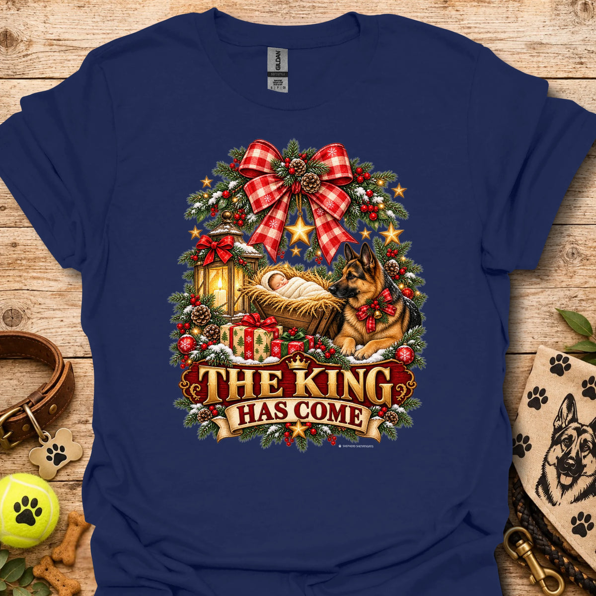 Navy holiday graphic T-shirt with wreath, dog, and “THE KING HAS COME” print