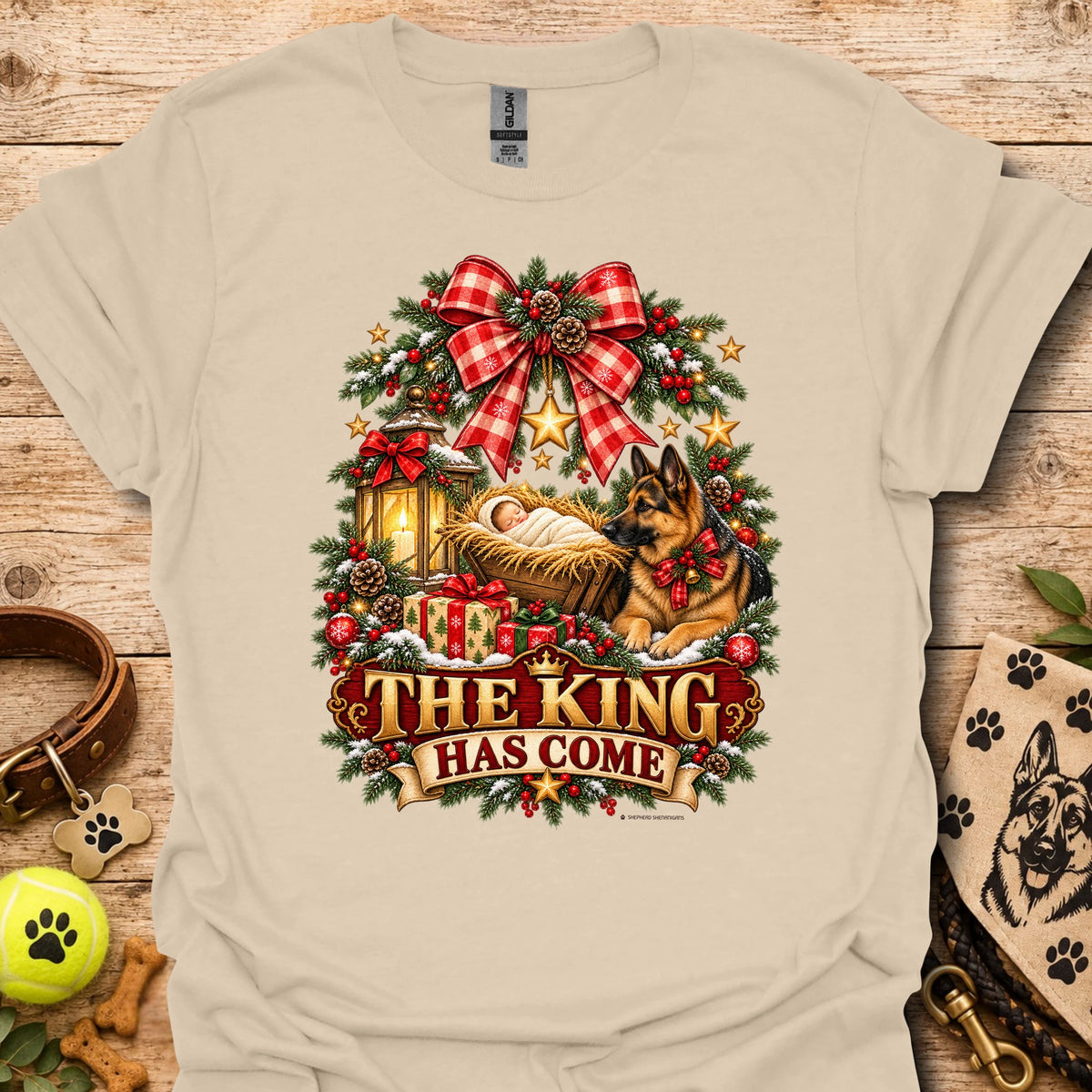 Sand/beige holiday graphic T-shirt with wreath, dog, and “THE KING HAS COME” print
