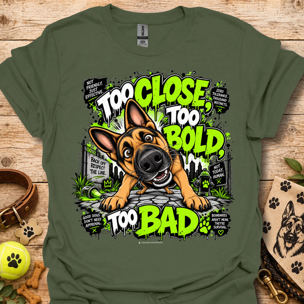 Military green T-shirt with cartoon dog graphic and neon 'Too Close Too Bold Too Bad' text