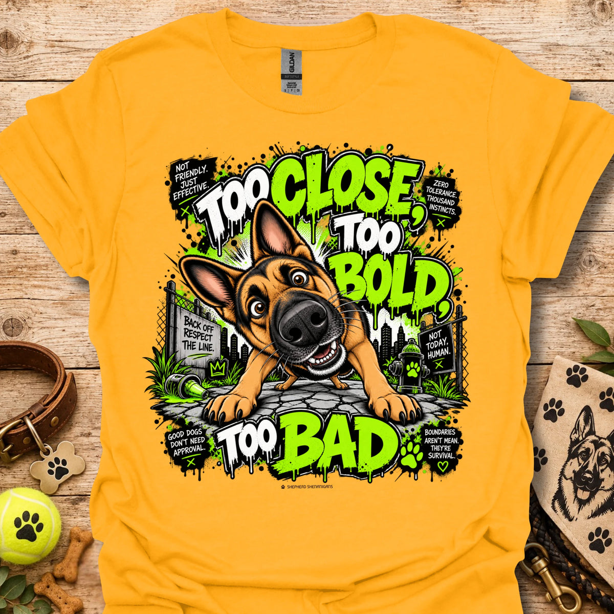 Gold T-shirt with cartoon dog graphic and neon 'Too Close Too Bold Too Bad' text