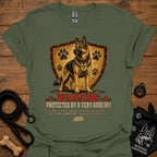 Military green dog graphic T-shirt with shield, paw prints, and “Warning” text
