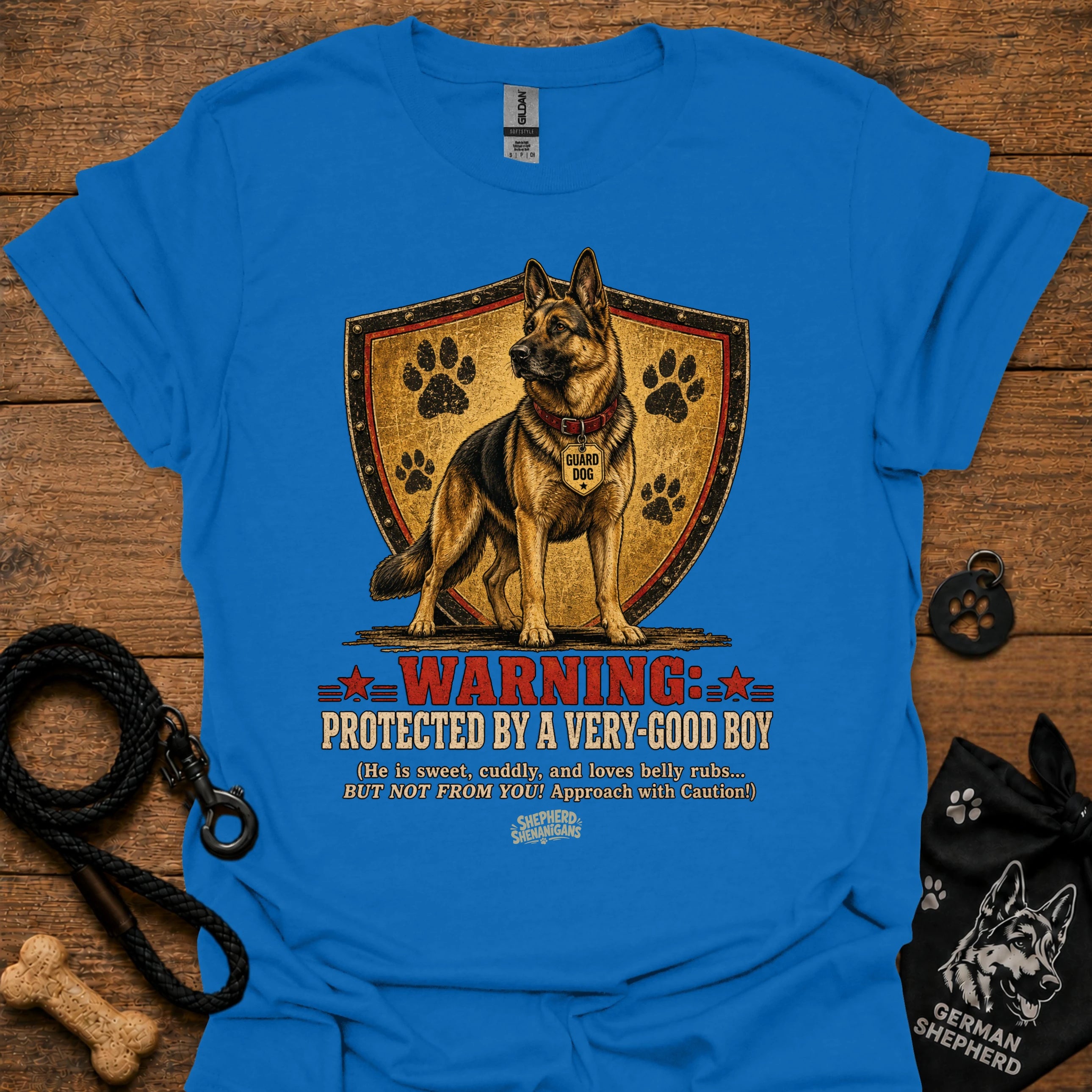 Royal blue dog graphic T-shirt with shield, paw prints, and “Warning” text