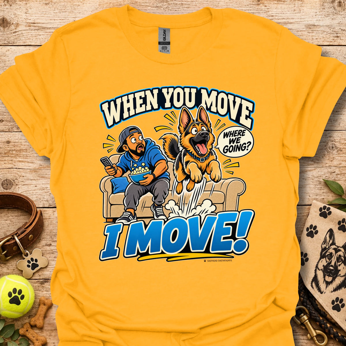Gold T-shirt with a cartoon man and dog leaping from a couch and bold slogan text.
